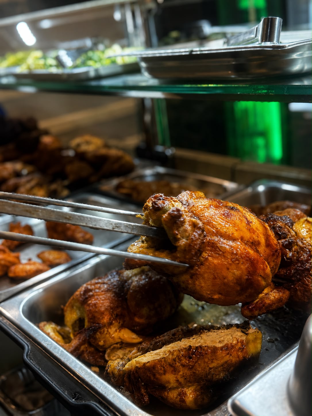 Pollo intero appena cotto allo spiedo, pelle dorata e croccante, su sfondo nero con illuminazione laterale